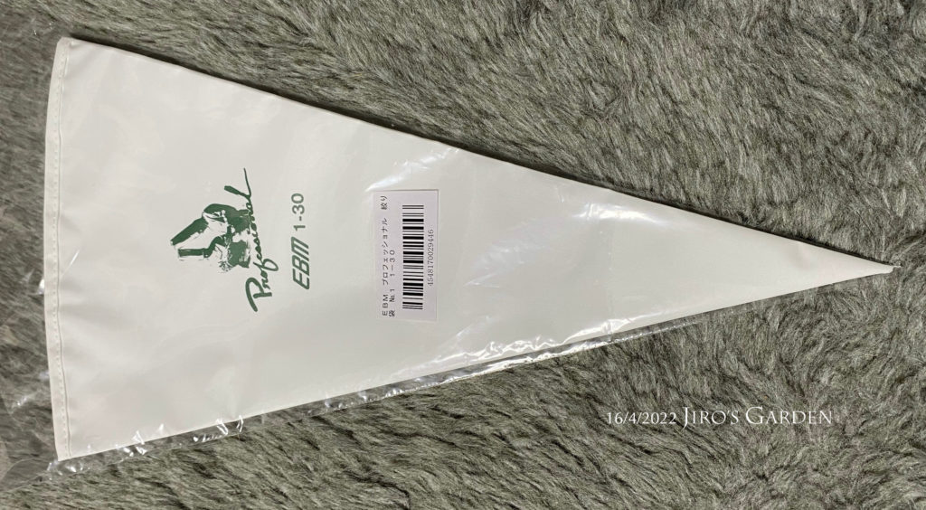 絞り袋の写真。白い素材にパティシエのイラストが緑色で描かれている。
