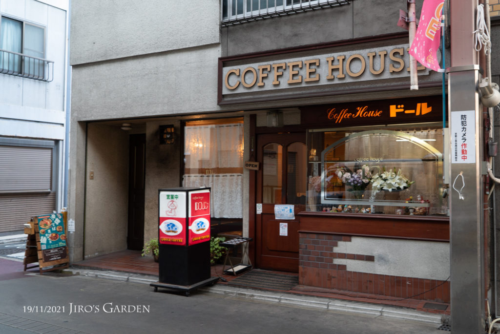 「Coffee House ドール」黒ベタの地にオレンジ文字の電照看板。懐かしい喫茶店の雰囲気。