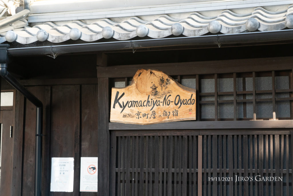 天然木の1枚板に「Kyomachiya-No-Oyado 京町屋の御宿」と書かれている。