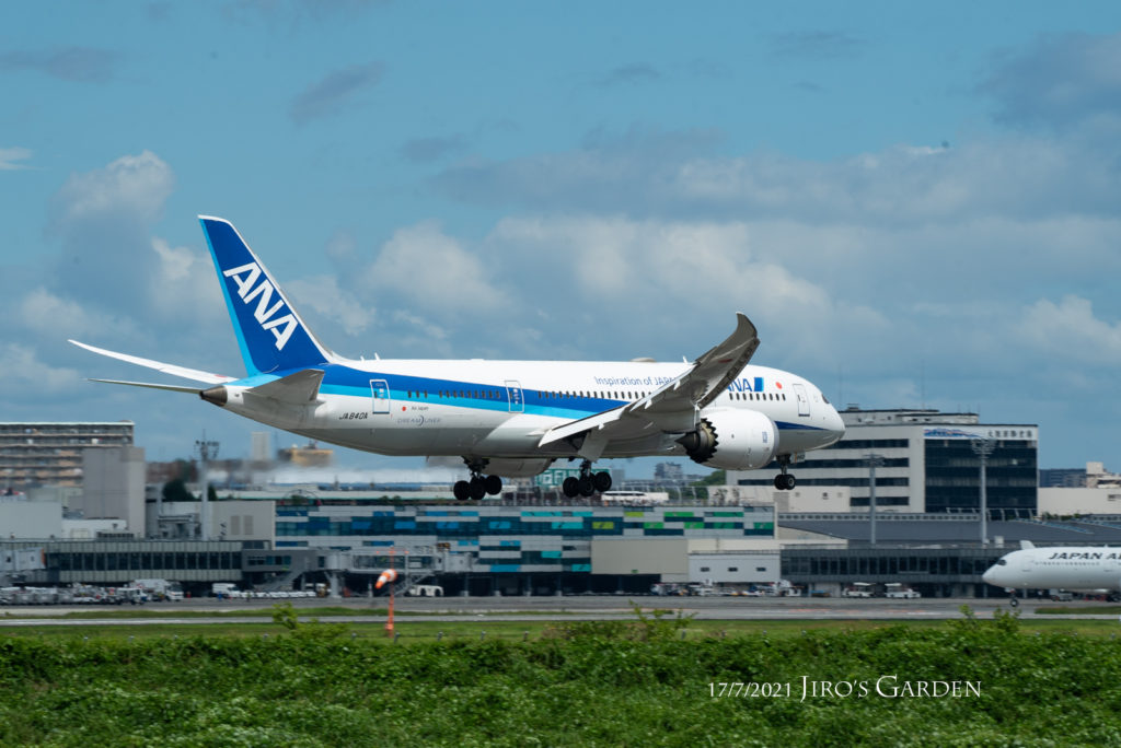 大阪国際空港のターミナルビルを背景に着陸寸前のB787
